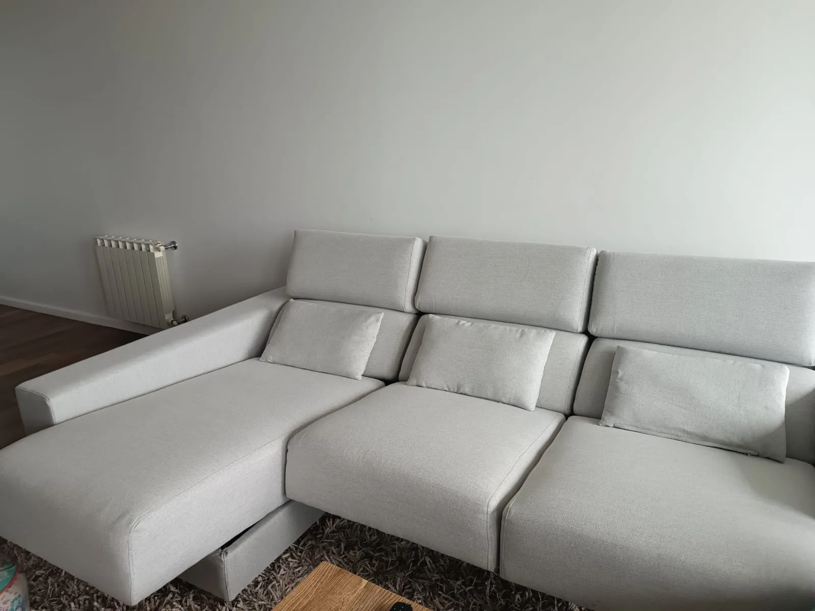 Sillón esquinero con chaise longue tapizado en tela crema